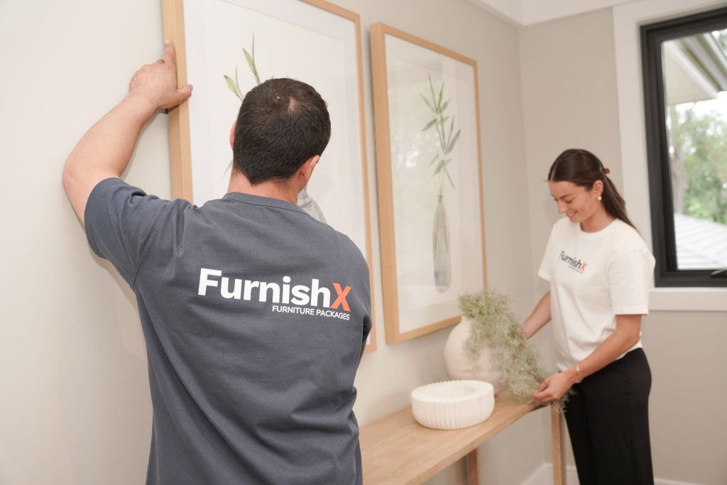 two FurnishX staff moving furniture into a living room and furnishing it